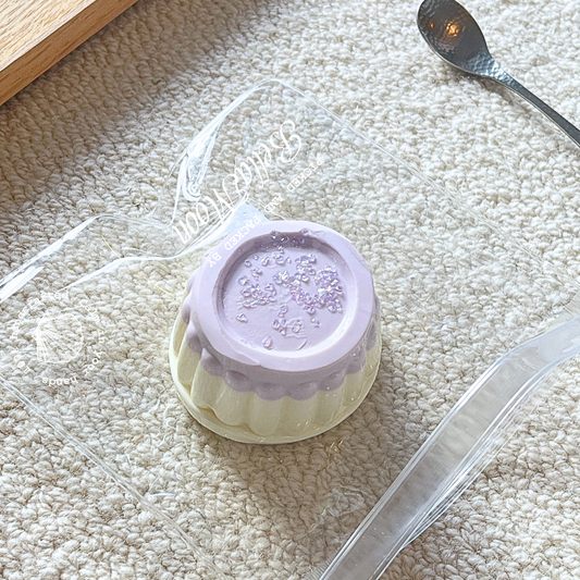 Purple taro puff cloud pudding squishy toy with whipped cream texture, 200g weight showing cloud-like compression for ADHD discrete stress relief